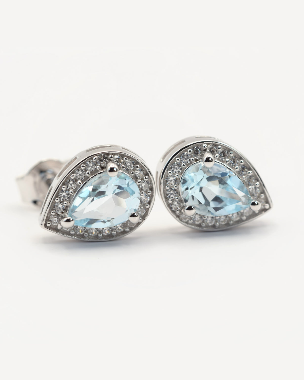 Nova Ohrstecker aus 925 Sterlingsilber mit Sky Blue Topas, Tropfen 5 x 7 mm und Zirkonia-Halo, Schrägansicht